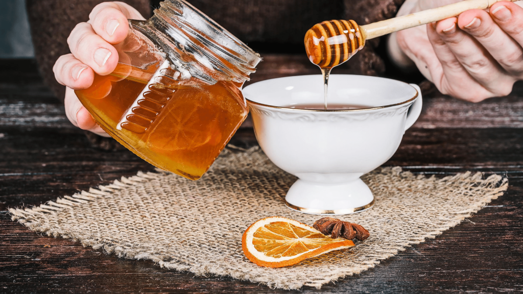 Adding honey to a cup of tea